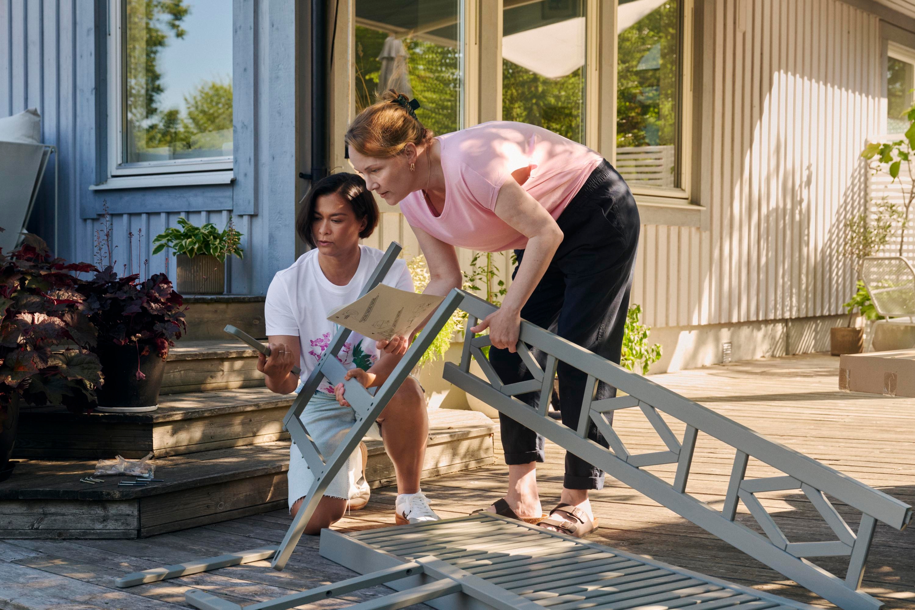 Two women building outdoor furnitures