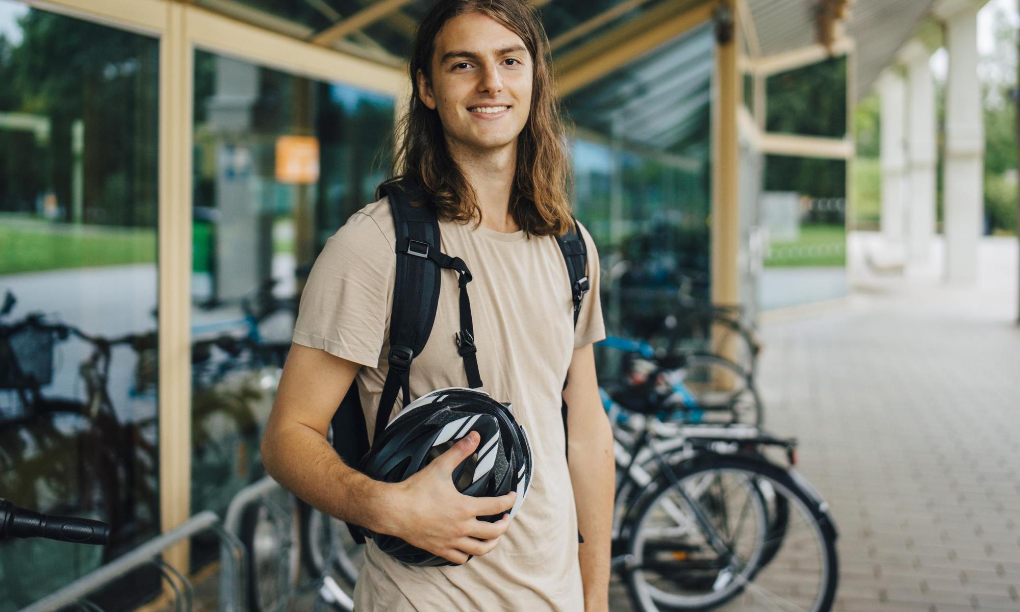 Young adult standing in front of his bike
