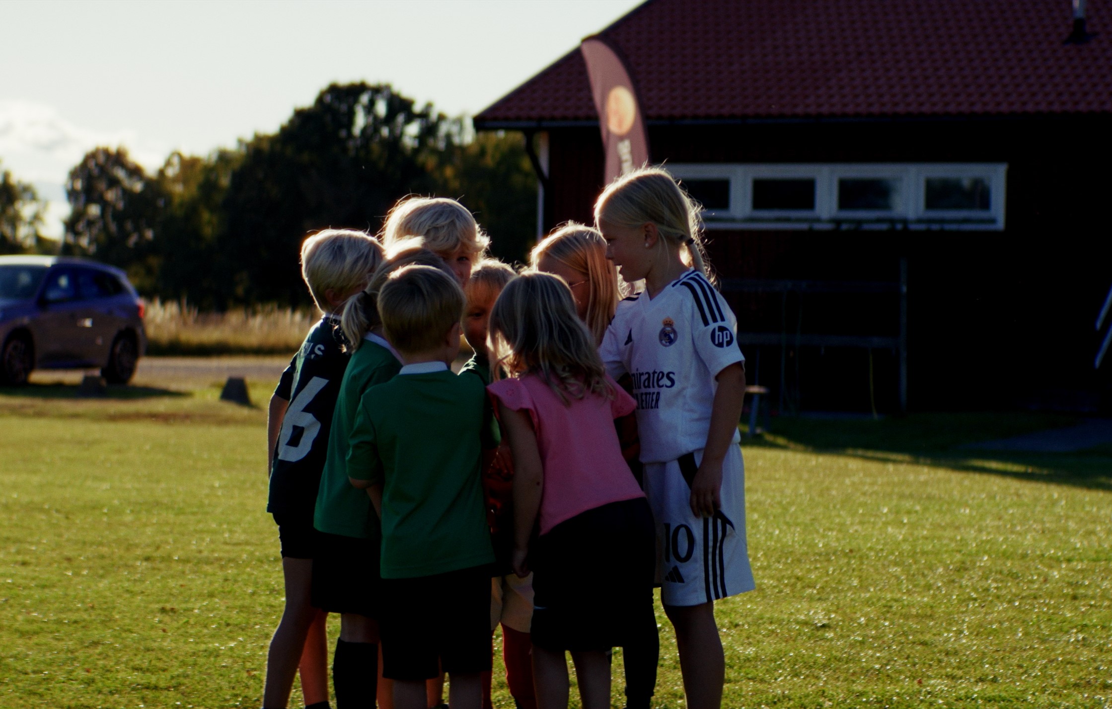 Barn står samlade på fotbollsplan